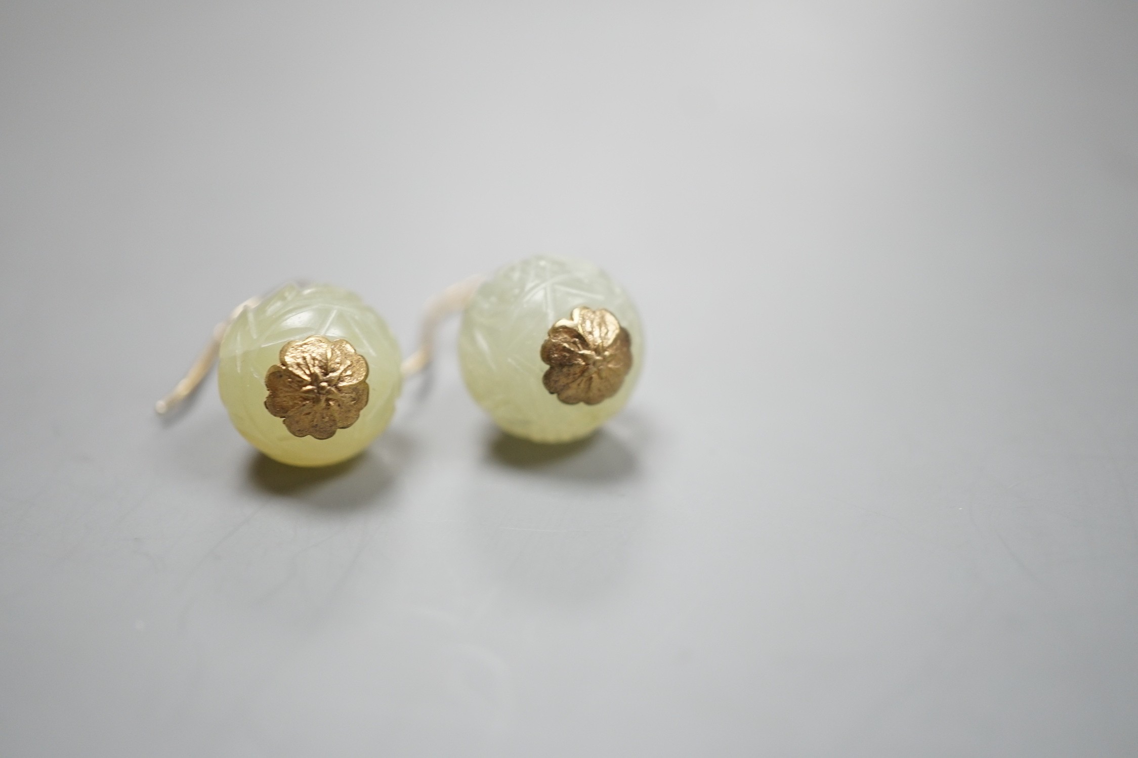 A pair of antique gilt metal and carved hardstone spherical drop earrings, jade diameter 14mm.